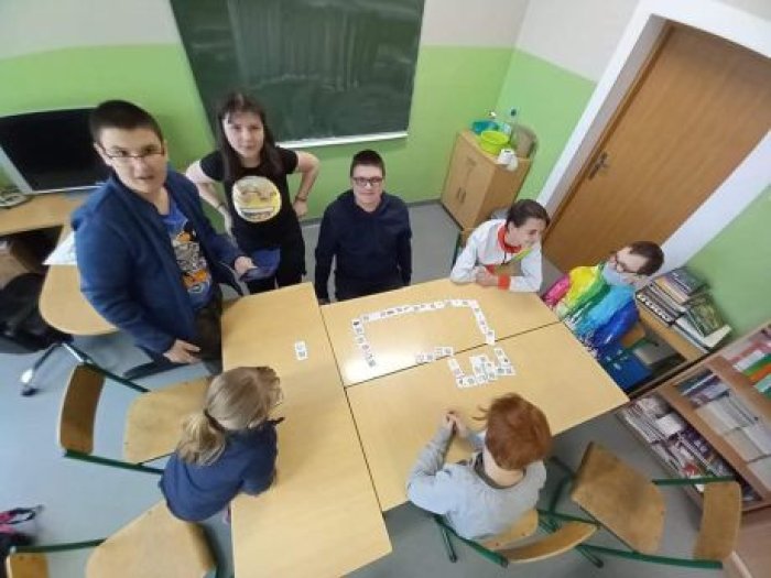 Uczniowie klasy 7 grają w domino ze skanerami kodów QR.