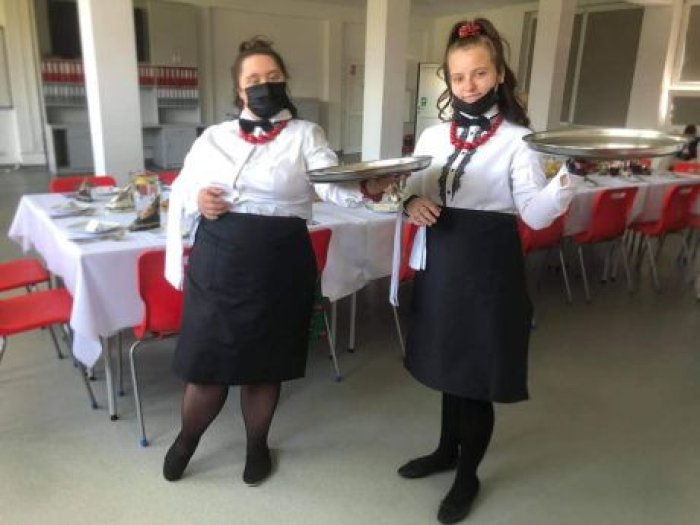 Uczennice klasy przysposabiającej do pracy prezentują umiejętności kelnerskie.