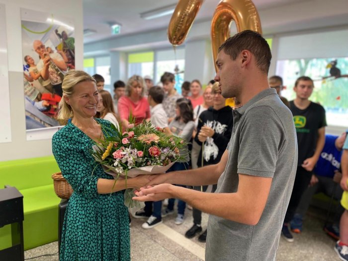 Uczniowie z nauczycielami i pracownikami szkoły składają życzenia.