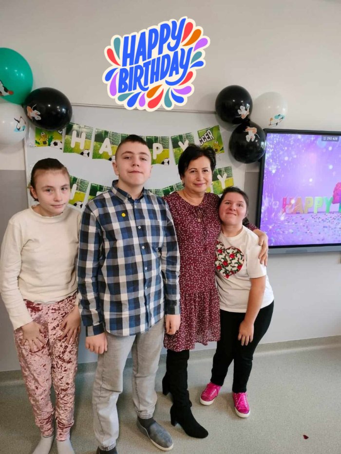 Solenizanci pozują do zdjęcia z panią wicedyrektor szkoły.