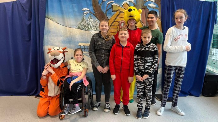 Uczniowie klasy szóstej pozują do zdjęcia wraz z maskotką Kubusia Puchatka i Króliczka.