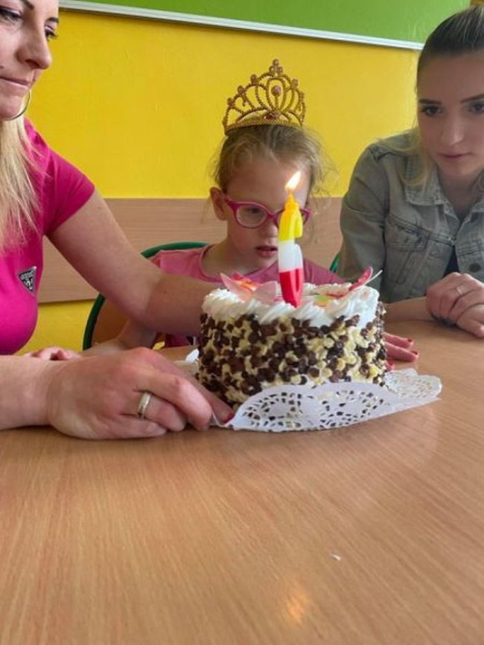 Lenka zdmuchuje świeczkę na torcie internetowym.