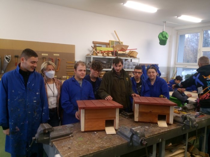 zdjęcie grupowe z P.Dyrektor , wychowawcami oraz wychowankami ośrodka oraz wykonanymi w pracowni domkami dla jeży.