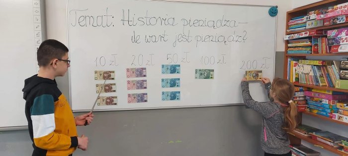 Uczniowie analizują na tablicy nominały