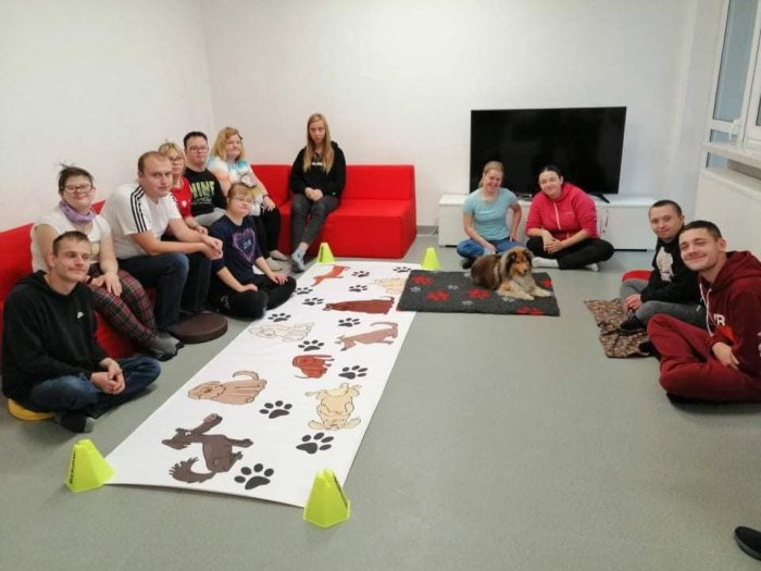 Uczniowie klas przysposabiających do pracy pozują do zdjęcia z psem terapeutycznym Kerrią.