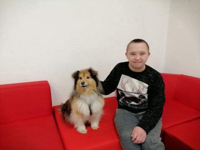 Uczeń głaska psa terapeutycznego.