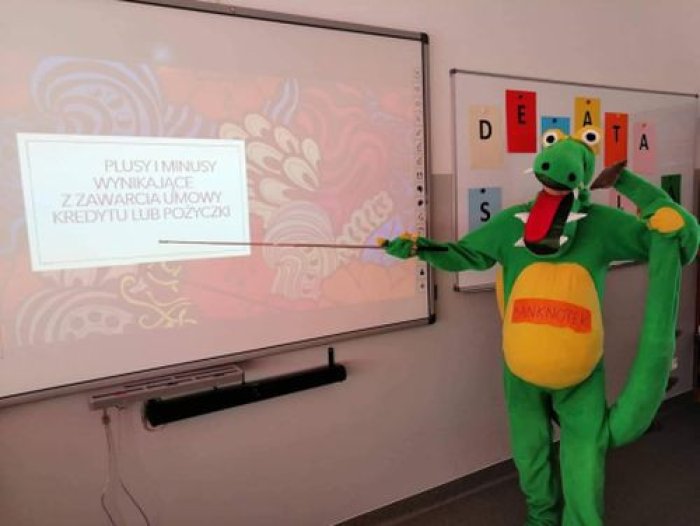 Smoczek Banknotek prowadzi debatę szkolną.