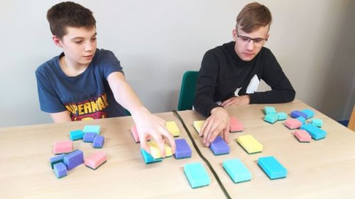 Podopieczni internatu doskonalą pojęcie osi symetrii za pomocą kolorowych gąbek.
