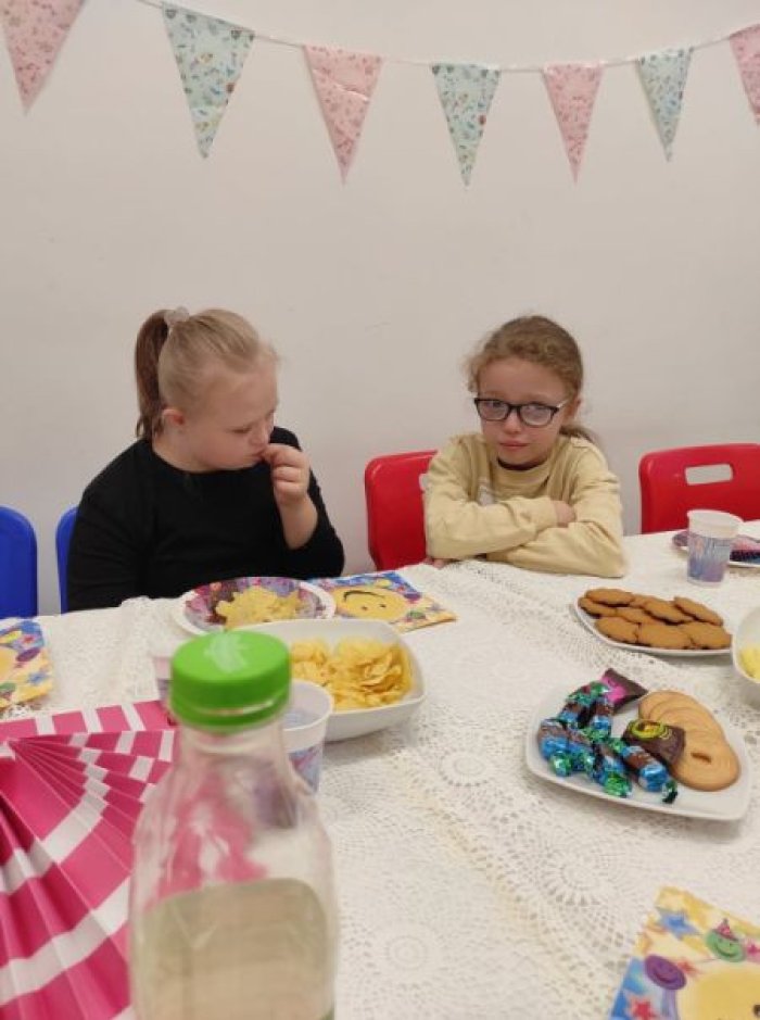 Uczennice degustują smakołyki urodzinowe.