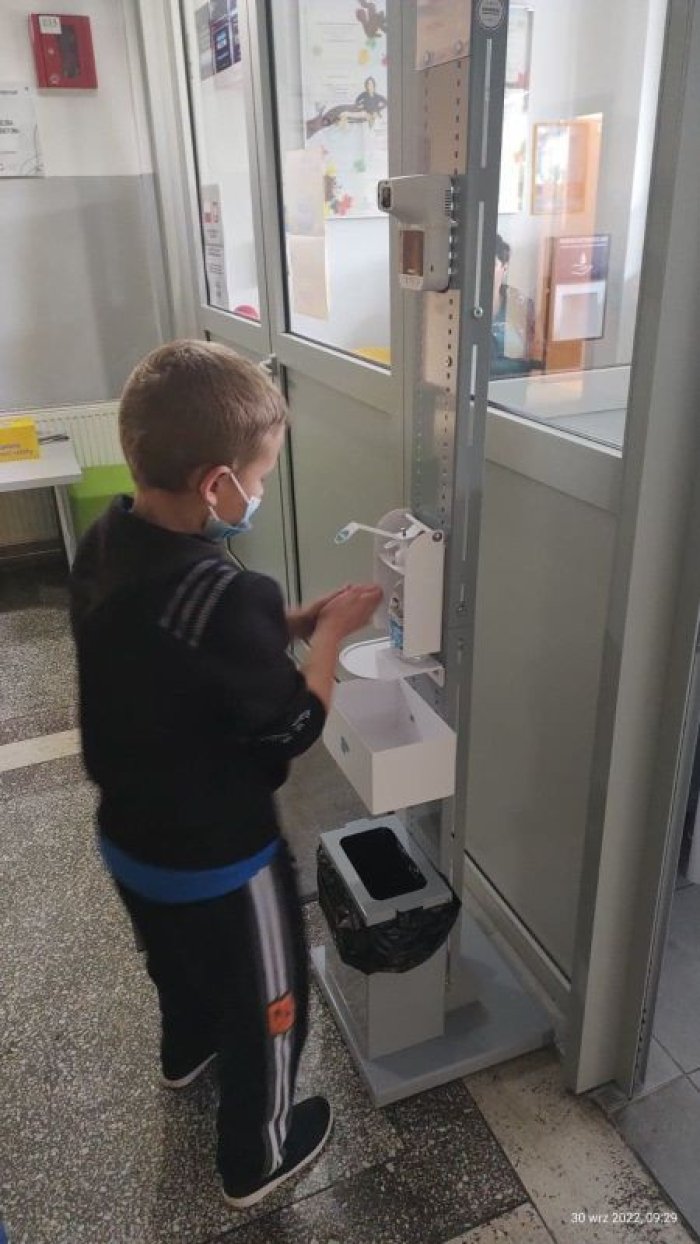 Uczeń dezynfekuje ręce.