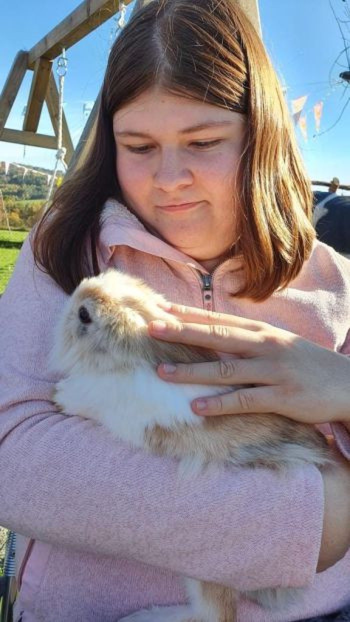 Uczennica głaszcze króliczka.