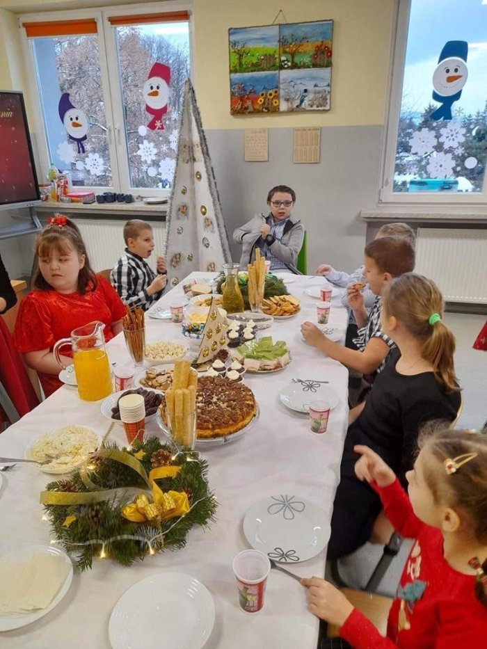 Uczniowie przy wigilijnym stole.