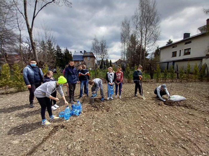 Uczniowie przygotowują się do sadzenia.